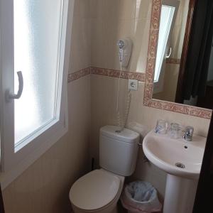 a small bathroom with a toilet and a sink at Hostal Carlos 2 in La Línea de la Concepción +17 photos