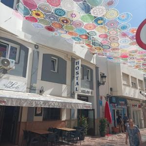 a woman walking down a street in front of a building at Hostal Carlos 2 in La Línea de la Concepción