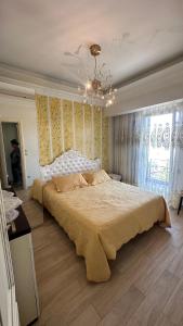 a bedroom with a large bed and a chandelier at Apartment Greek Mansion in Nea Moudania