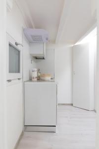 a white room with a white refrigerator and a tv at Casa Cartoleria 34 in Bologna +18 photos