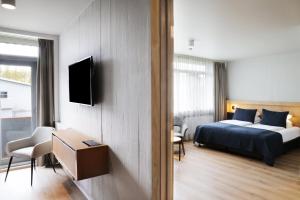 雷克霍特Fosshotel Reykholt的一间卧室，墙上有一张床和一台电视