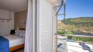 a bedroom with a bed and a window with a view at Alojamento Armando Monteiro in Folgosa