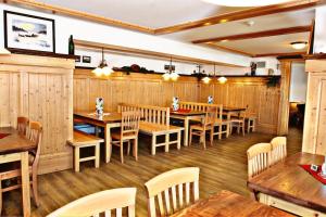 un restaurante con mesas de madera y sillas de madera en Arberschutzhaus, en Bayerisch Eisenstein