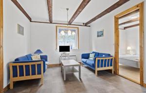 a living room with two blue chairs and a tv at 2 Bedroom Stunning Apartment In Faaborg in Fåborg