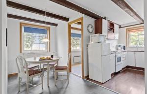 a kitchen with a table and a white refrigerator at 2 Bedroom Stunning Apartment In Faaborg in Fåborg