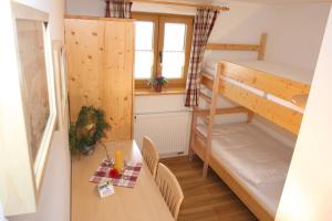 バイエリッシュ・アイゼンシュタインにあるArberschutzhausのテーブルと二段ベッド付きの小さな部屋です。