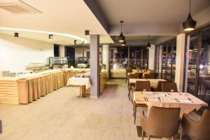 a restaurant with tables and chairs and a counter at Hotel Evropa in Ulcinj
