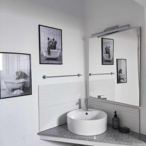 un bagno bianco con lavandino e specchio di Giannis house a Nea Makri