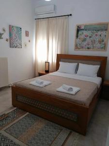 una camera da letto con un letto con due asciugamani sopra di Giannis house a Nea Makri