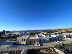 a group of white buildings with the ocean in the background at Aetheria Apartment with Private Pool in Kampos Paros