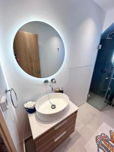 a bathroom with a sink and a mirror at Aetheria Apartment with Private Pool in Kampos Paros +19 photos