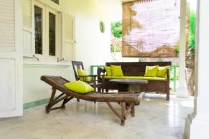 a porch with a bench and a yellow couch at Villa Moya Borobudur in Mendut