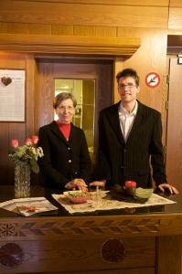 mężczyzna i kobieta stojący przy stole w obiekcie Hotel Diana w mieście Canazei