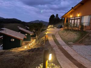 a house with lights on the side of a road at Altos da Mantiqueira Chalés -Grupo Vertentes in Santo Antônio do Pinhal