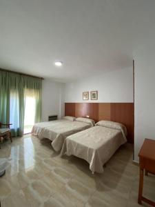 Łóżko lub łóżka w pokoju w obiekcie Hotel Muñoz