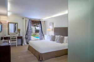 a hotel room with a bed and a desk and a room at Princess Resort, Santikos Collection in Agia Paraskevi