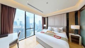 Schlafzimmer mit einem Bett, einem Schreibtisch und einem großen Fenster in der Unterkunft Imperial KLCC Residence in Kuala Lumpur + 37 Fotos