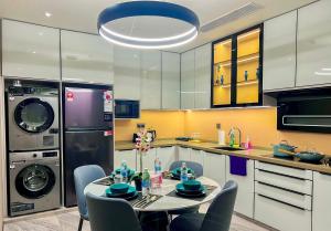 eine Küche mit einem Tisch mit Stühlen und einem Kühlschrank in der Unterkunft Imperial KLCC Residence in Kuala Lumpur