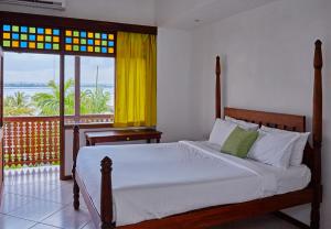 een slaapkamer met een bed en uitzicht op de oceaan bij Hotel Slipway in Dar es Salaam