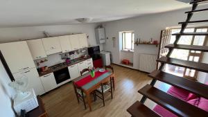 a small kitchen with a table and a spiral staircase at Casetta Sant'Angelo in SantʼAngelo
