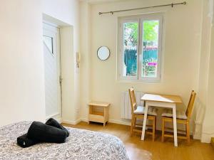 a room with a bed and a table and a window at Le petit meublé hyper Centre in Orléans