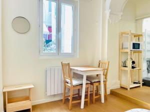 a table and chairs in a room with a window at Le petit meublé hyper Centre in Orléans +9 photos