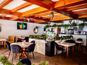 a restaurant with tables and chairs and a bar at Góral Spa&Wellness in Szczyrk +28 photos