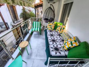 a balcony with a couch and chairs on a balcony at Ermina House in Skiathos