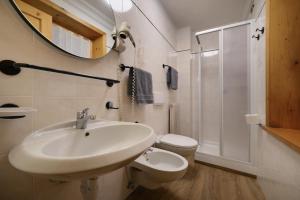 a bathroom with a sink and a toilet and a mirror at Baita La Fonte in Livigno