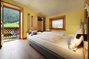 a bedroom with a large bed and a large window at Baita La Fonte in Livigno
