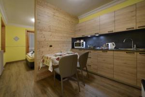 a kitchen with a table with chairs and a microwave at Baita La Fonte in Livigno