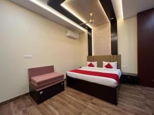 a hotel room with a bed and a chair at Mayur Palace Hotel in Agra