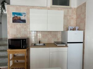Una cocina con un refrigerador blanco y un microondas. en Casa Stella del Vesuvio, en Portici 5 fotos más