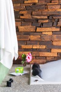 a bedroom with a brick wall and a vase with flowers at Altos da Mantiqueira Grupo Vertentes in Santo Antônio do Pinhal