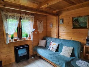 a living room with a blue couch and a fireplace at Nowoczesny Domek Góralski in Kielce