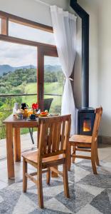 a dining room with a table and a wood stove at Altos da Mantiqueira Grupo Vertentes in Santo Antônio do Pinhal