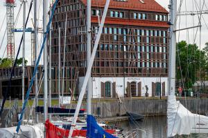 a large building with a bunch of boats in the water at Old Mill Hotel in Klaipėda