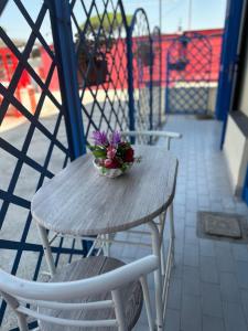 Una mesa de madera con un cuenco de flores encima. en Casa Stella del Vesuvio, en Portici