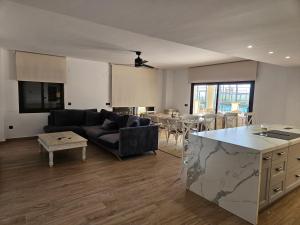 ein Wohnzimmer mit Sofa und Tisch in der Unterkunft Luxury 3 bed apartment Marina de la Duquesa, huge terrace pool views, 500 meters to Beach in Manilva
