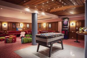 a living room with a pool table in the middle at Sunstar Hotel Klosters in Klosters