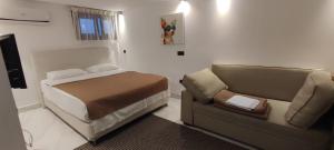 a small bedroom with a bed and a couch at Kali lux duplex in Kallithea Halkidikis +42 photos