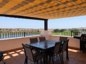stół i krzesła na balkonie z widokiem w obiekcie Luxury 2 bed Penthouse on Golf Course Murcia w mieście Sucina