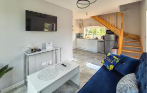 Una sala de estar con un sofá azul y una mesa. en 3 Bedroom Nice Home In Wapnica, en Wapnica