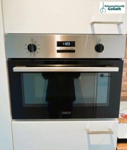 a silver and black oven in a white kitchen at Houseboat Tjonger NS003 in Monnickendam +21 photos
