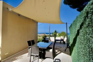 un patio con mesa, sillas y seto en Villa Betty, en Denia