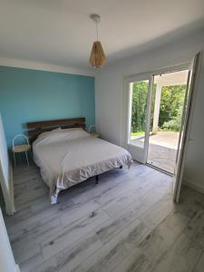 a bedroom with a bed and a sliding glass door at Socoa : appartement calme à 200m de la plage in Ciboure