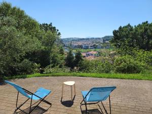 two chairs and a table on a brick patio at Socoa : appartement calme à 200m de la plage in Ciboure