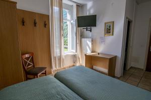 una camera da letto con un letto, una scrivania e una finestra di Albergo Stazione a Bodio