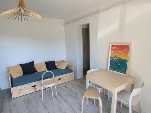 a living room with a bed and a table and chairs at Socoa : appartement calme à 200m de la plage in Ciboure +6 photos