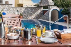 a table with food and drinks on it next to a pool at Villa Margarita in Karterados